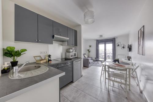 une cuisine avec un évier et une table à l'intérieur dans l'établissement Central 3 - 10 min Paris - 30 min Disney - Free Parking - 5 min RER A, à Fontenay-sous-Bois
