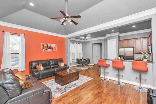 a living room with a leather couch and orange walls at Prolific 3Story w Game Room-HotTub-Near DT in Houston