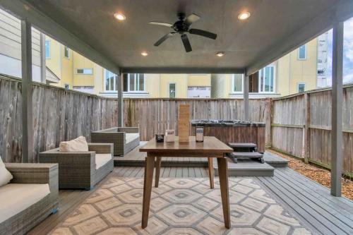 a screened in porch with a table and a ceiling fan at Prolific 3Story w Game Room-HotTub-Near DT in Houston
