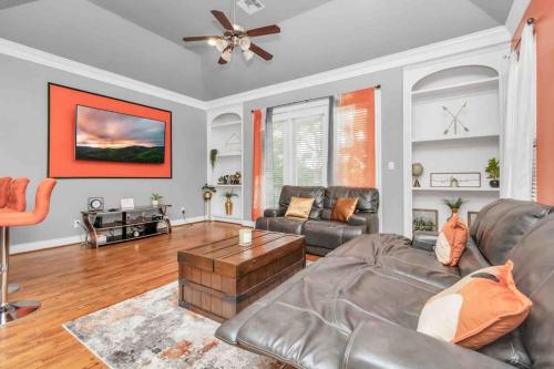 a living room with a leather couch and a table at Prolific 3Story w Game Room-HotTub-Near DT in Houston