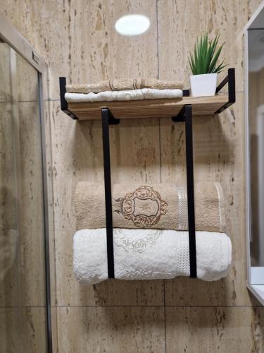 a group of towels on a shelf in a bathroom at Crăițelor Boutique Airport Apartment in Otopeni