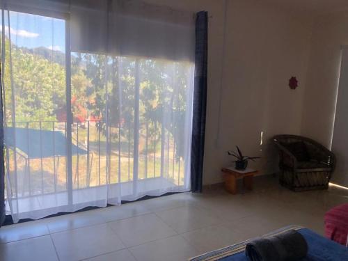 ein Wohnzimmer mit einem großen Fenster und einem Balkon in der Unterkunft casa tranquila in Santo Domingo Ocotitlán