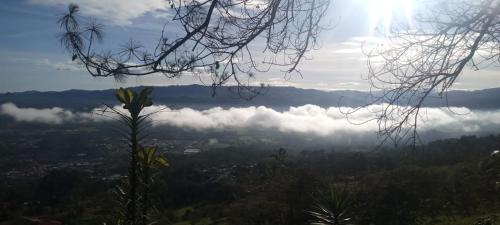 a view of a valley with clouds in the sky at Hotel Green Mountain turrialba in Turrialba