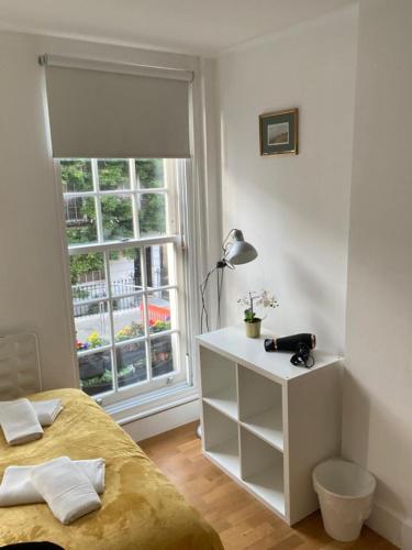 a bedroom with a bed and a window at Lovely Private Rooms in Euston, Central London in London