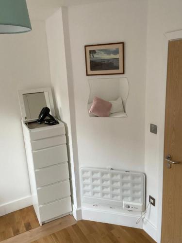 a room with a white wall with a phone on the wall at Lovely Private Rooms in Euston, Central London in London