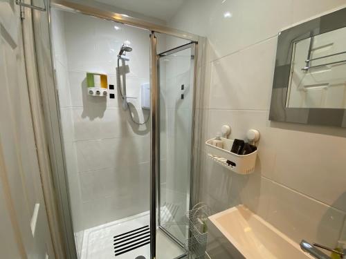 W łazience znajduje się prysznic ze szklanymi drzwiami. w obiekcie Peacock Guest House w mieście Largs