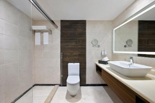 a bathroom with a white toilet and a sink at Holiday Inn Jeddah Corniche, an IHG Hotel in Jeddah