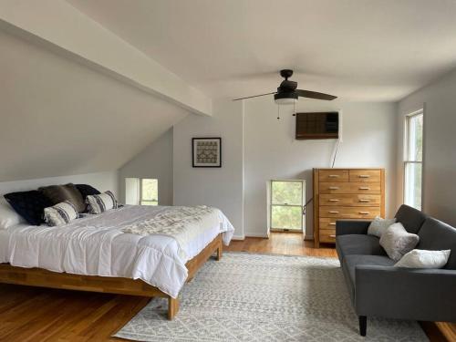 a bedroom with a bed and a couch at Colonial Chic - 3BR home, VA wine country near Harpers Ferry in Purcellville