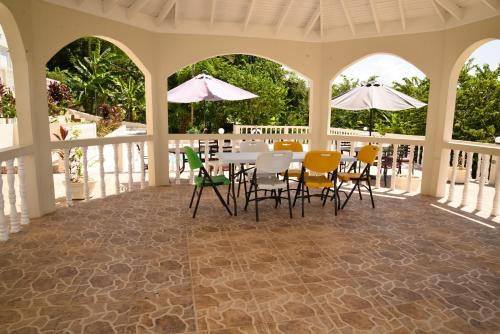 a porch with a table and chairs and umbrellas at Retreat Guest House in Falmouth