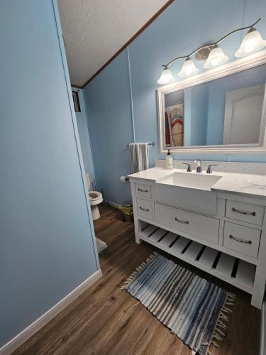 een badkamer met een witte wastafel en een spiegel bij Camp Joy Lake House, Caldwell, TX sleeps 10 in Caldwell
