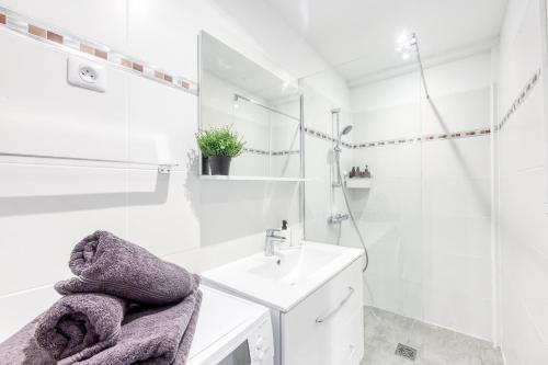 une salle de bain blanche avec un lavabo et un miroir dans l'établissement Central 5 - 10 min Paris - 30 min Disney - Free Parking - 5 min RER A, à Fontenay-sous-Bois