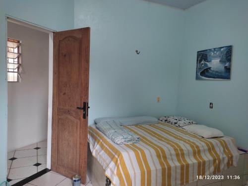 een slaapkamer met een bed en een open deur bij Linda casa em marudá in Maruda