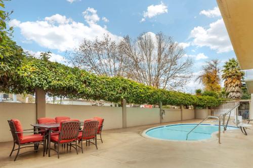 a patio with a table and chairs next to a pool at Best Western Plus Airport Plaza in San Jose