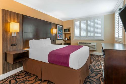a hotel room with a large bed and a desk at Best Western Plus Airport Plaza in San Jose