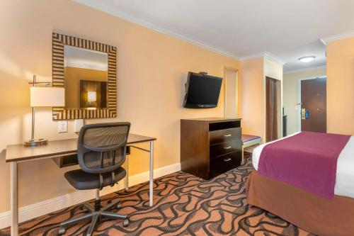 a hotel room with a bed and a desk and a computer at Best Western Plus Airport Plaza in San Jose