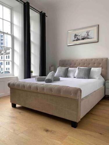 a large bed in a bedroom with a large window at Grand Apartment on HOE/BARBICAN Allocated PARKING! in Plymouth