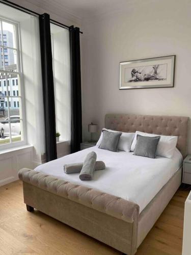 a large bed in a bedroom with a large window at Grand Apartment on HOE/BARBICAN Allocated PARKING! in Plymouth