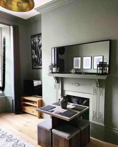 a living room with a fireplace and a table at Grand Apartment on HOE/BARBICAN Allocated PARKING! in Plymouth