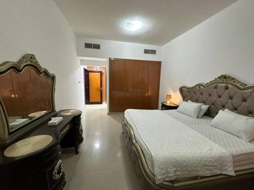 a bedroom with a large bed and a desk at Amazing Beachfront Holiday Home in Ajman 