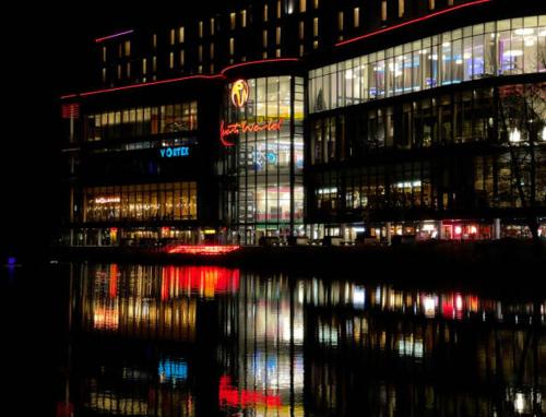 a large building with lights on the water at night at Johal Accommodation Ltd- NEC 1 bedroom studio apartment with free parking in Sheldon