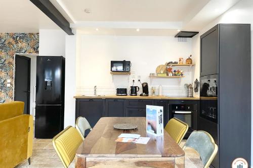 une cuisine avec une table en bois et des chaises jaunes dans l'établissement The Central Station - 50m Gare, à Rouen