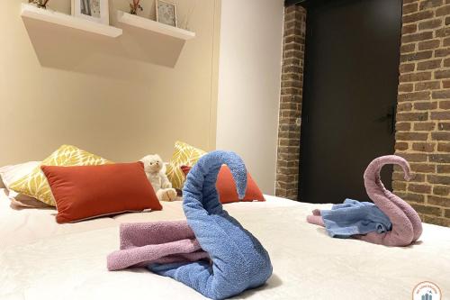 - un lit avec 2 cygnes en serviettes dans l'établissement The Central Station - 50m Gare, à Rouen