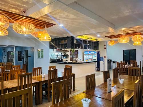 ein Restaurant mit Holztischen, Stühlen und Lampen in der Unterkunft Funtasea Hotel and Beach Resort in Iba