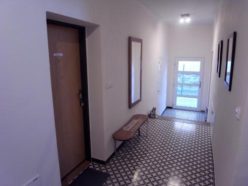 a hallway with a door and a bench on a tiled floor at Apartmány Pekárna in Staré Město