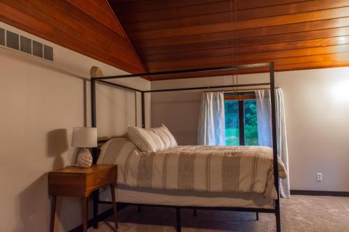 a bedroom with a canopy bed with a window at Dogwood Retreat with big pool! in Warsaw