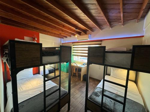 a dorm room with three bunk beds in it at Paris Hostel in Tijuana