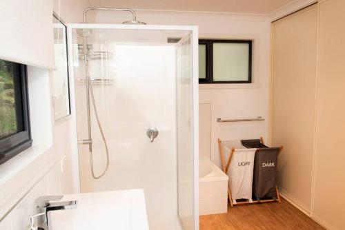 baño con ducha y puerta de cristal en Majestic 2 bedroom villa with panoramic bay views, en Strahan
