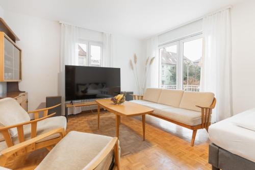 uma sala de estar com um sofá e uma televisão em Bodensee-Haus IStayUnixI Seenähe-Terrasse-Garten-Netflix-Parkplatz em Radolfzell am Bodensee