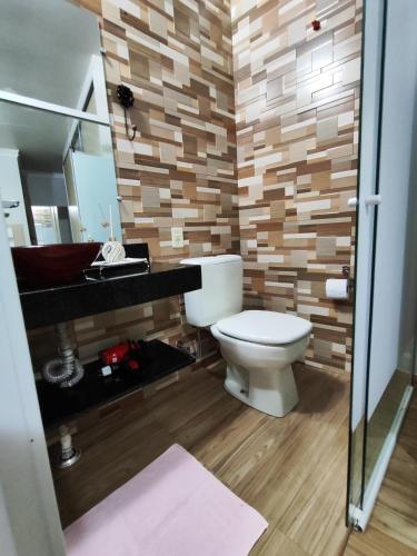 a bathroom with a toilet and a sink and a mirror at Aconchego perto das Cataratas. in Foz do Iguaçu