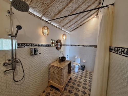 La salle de bains est pourvue d'une douche et de toilettes. dans l'établissement La Colina Bungalow, à Nusa Penida