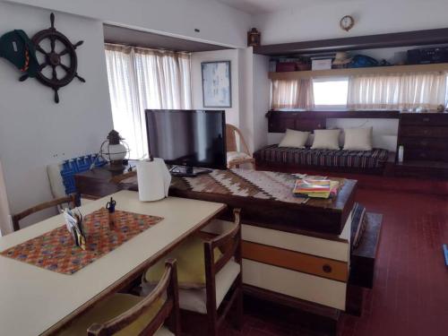 sala de estar con mesa y sofá en Monoambiente en Villa Gesell