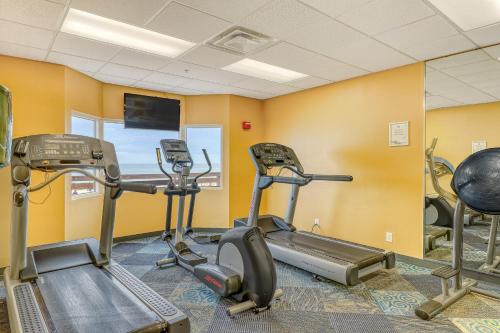 a gym with several tread machines in a room at Tidewater Beach Resort in Panama City Beach