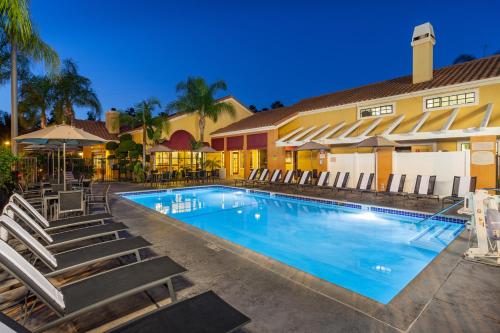 a swimming pool with a pool table and chairs at Clementine Hotel & Suites Anaheim in Anaheim