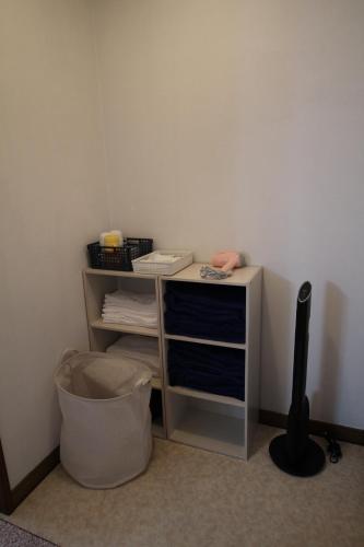 a small desk with a trash can in a room at 貸切民泊勝山ベース325 福井県立恐竜博物館まで車で5分 in Kitarokuroshi