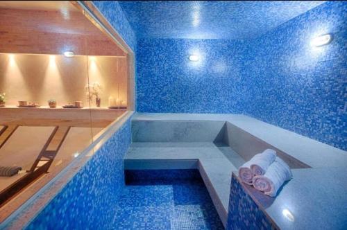 a blue bathroom with a tub and a shower at Hotel Vision in Brasilia