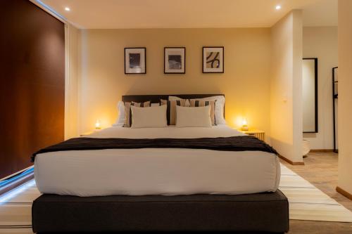 a bedroom with a large white bed with two lamps at Capitalia Galileo Residences in Mexico City