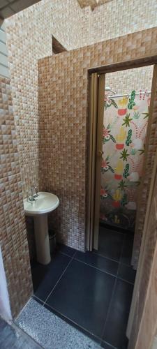 La salle de bains est pourvue d'un lavabo et d'une porte ouverte. dans l'établissement Quarto perto Pelourinho, à Salvador