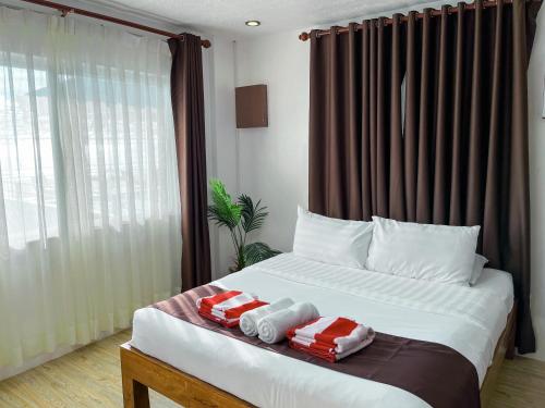 a bedroom with a bed with two towels on it at Funtasea Hotel and Beach Resort in Iba