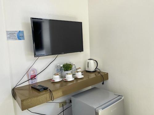 a flat screen tv sitting on a shelf in a room at Funtasea Hotel and Beach Resort in Iba