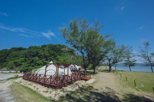 a large tent in a field next to a river at Yagaji Beach(屋我地ビーチ) in Nago