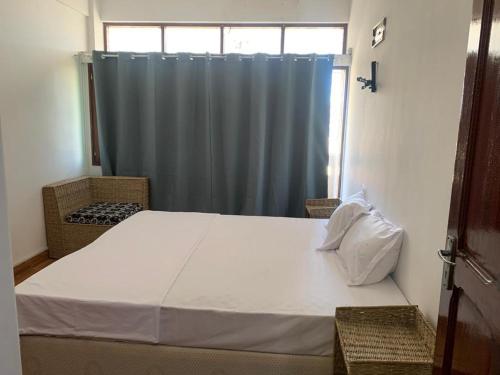 a bedroom with a large bed with a blue curtain at Chambre Centre de Maputo in Maputo