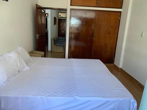 a large white bed in a room with a door at Chambre Centre de Maputo in Maputo