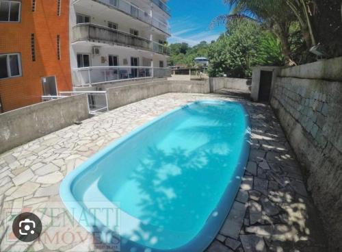 a large blue swimming pool on a stone patio at Solar Camorim in Angra dos Reis