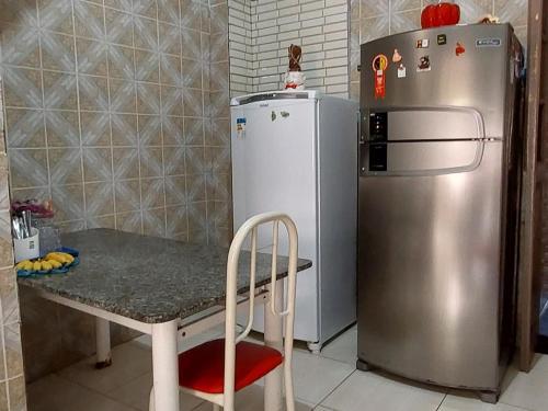 une petite cuisine avec une table et un réfrigérateur dans l'établissement Quarto perto Pelourinho, à Salvador