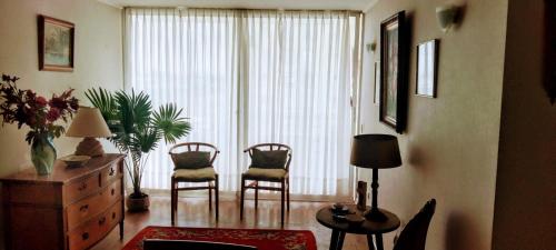 sala de estar con sillas y ventana grande en Departamento en Barrio Exclusivo - La Serena, en La Serena