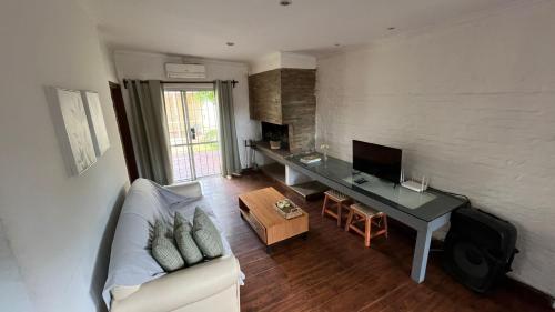 sala de estar con sofá y escritorio en Casa cabaña, en Paysandú